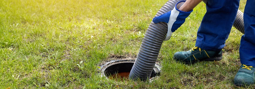 technician opening lid to pump a septic system